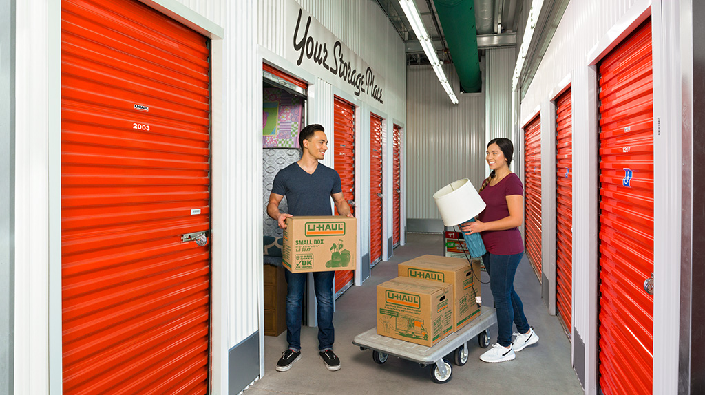 Customers loading their storage unit with a lamp and boxes.