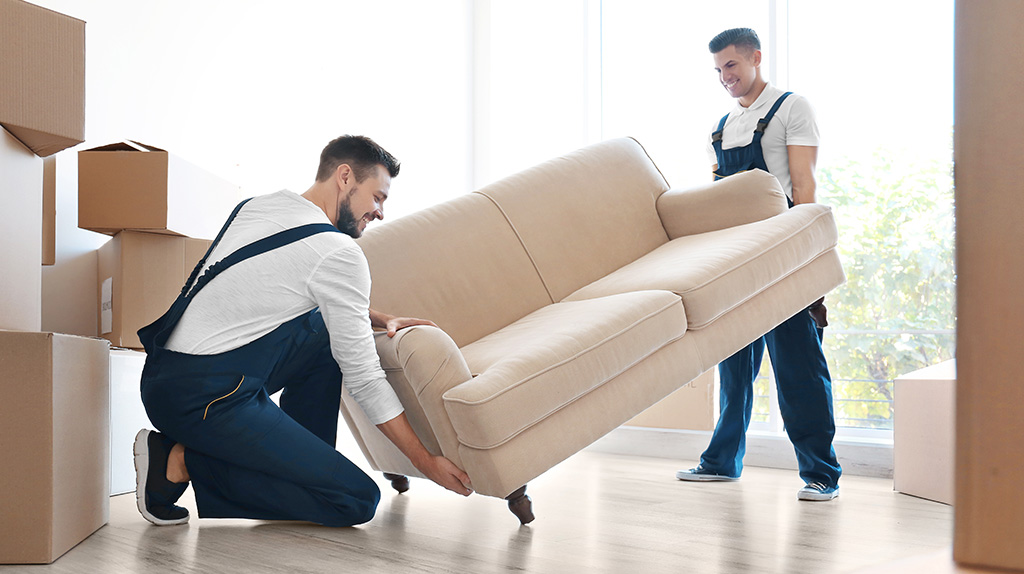 Two movers lifting a couch while completing a customer's move.
