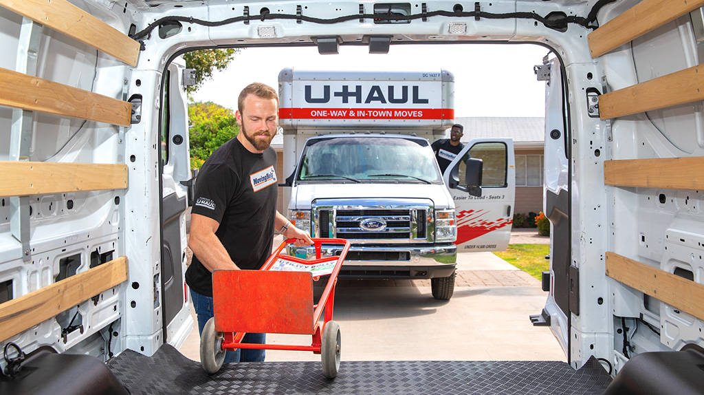 Mover putting a hand truck into a moving van.