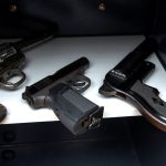 Three guns are about to be removed from a gun safe, so the owner can safely move the gun safe.