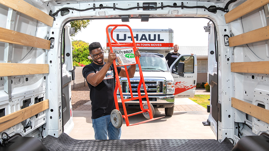 A professional moving labor provider from the Moving Help Marketplace loads a dolly into a U-Haul truck.
