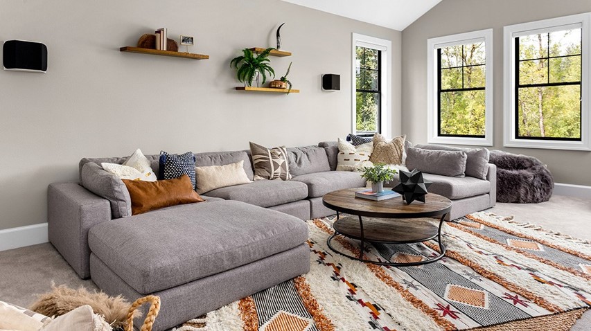 Gray sectional couch sits in well lit living room.