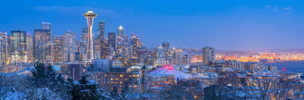 A cold, winter evening can be seen as snow covers the Seattle ground and downtown area.