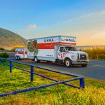 A U-Haul truck rental pulls a trailer driving to Oregon.