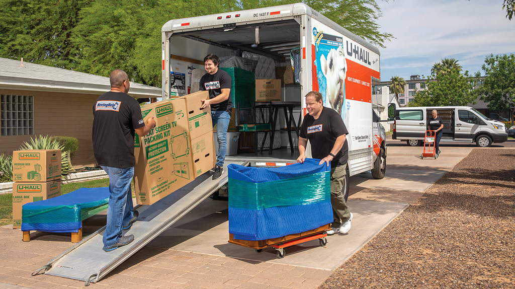 Moving Help Service Providers load different items into a U-Haul truck for a customer.