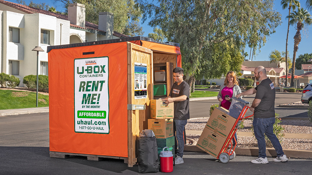 Two Moving Help Service Providers help a customer by loading her belongings into her U-Box container.