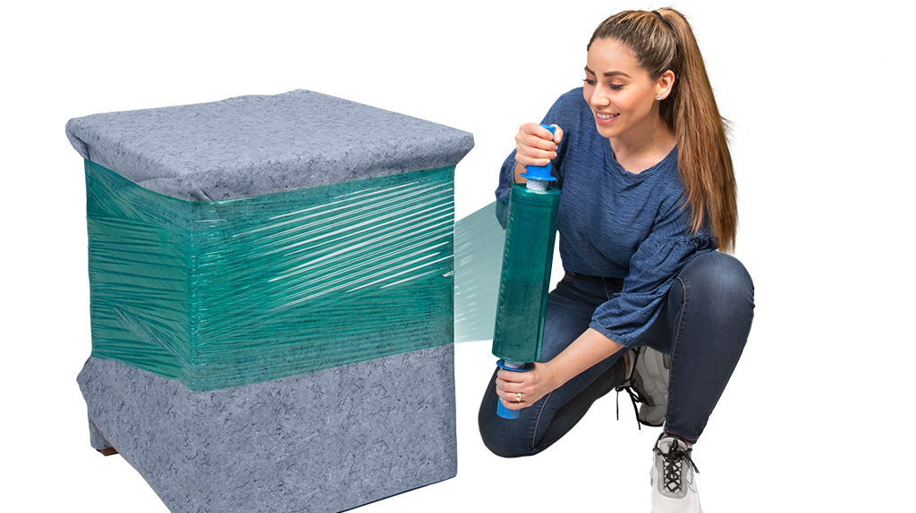 A woman uses stretch wrap to wrap a furniture pad, which are both items needed for local movers.