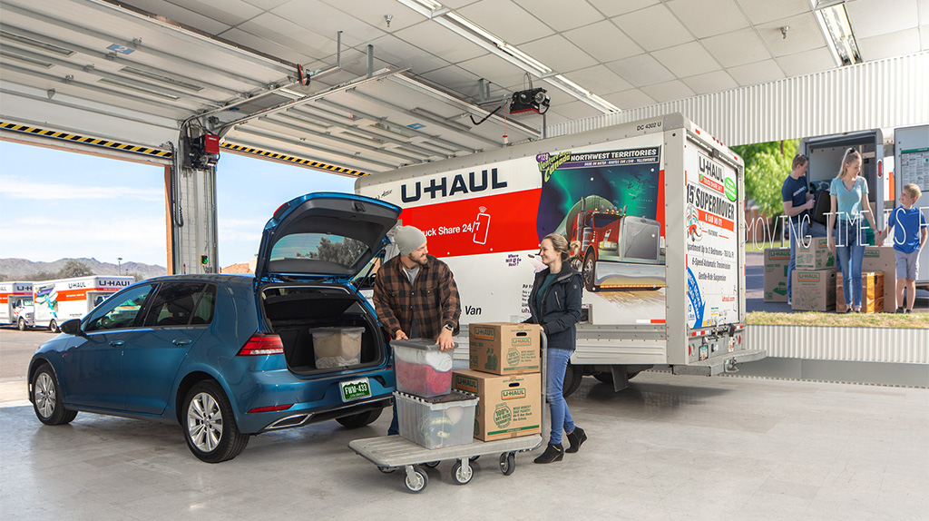 A couple begins loading moving boxes into their car. Customers can rent car storage to leave their car while it’s not in use for long periods at a time.