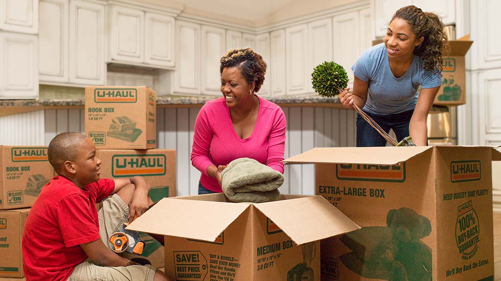 A family begins to pack their belongings into U-Haul moving boxes. U-Haul moving boxes are made to be sturdy and strong for any moving job.