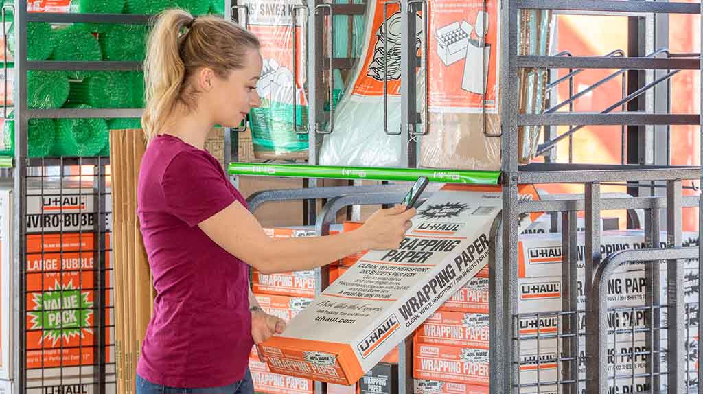 A customer considers purchasing wrapping paper at a U-Haul center.