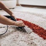 A person starts to deep clean their carpet with their cleaning equipment.