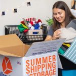A college student begins to pack her dorm room belongings into a Collegeboxes moving box.