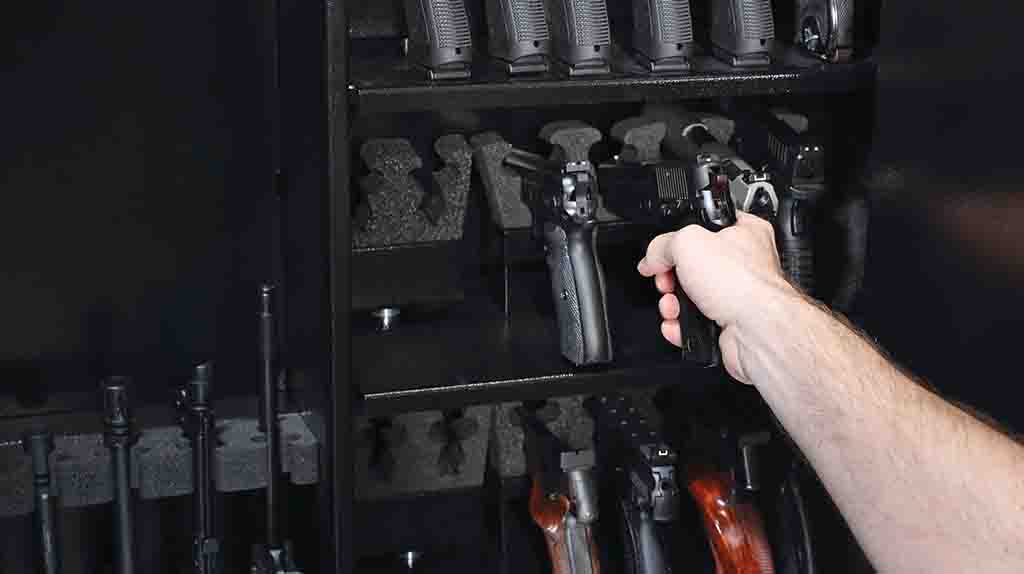 A customer begins to carefully unload guns out of a gun safe in preparation of moving it with help from Moving Help.