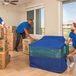 Three Moving Helpers carefully prepare to begin moving a customer’s belongings for the customer’s long-distance move.