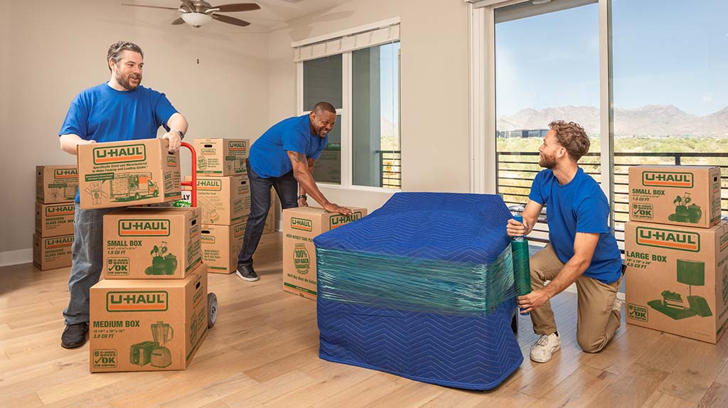 Three Moving Helpers carefully prepare to begin moving a customer’s belongings for the customer’s long-distance move.