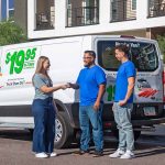 A woman hands a cash tip to the two Service Providers for a job well done after completing her move.