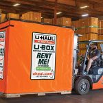 A U-Haul employee carefully moves a U-Box container that'll be sent internationally.