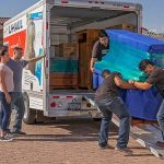 Services Providers load an upright piano into a U-Haul truck rental.
