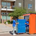 Two Moving Helpers prepare to carefully load a piece of furniture into a U-Box storage and moving container for a customer.