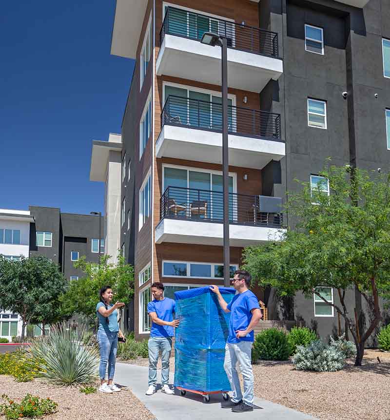 A customer talks to two Moving Help moving labor providers about where she wants the piece of furniture they’re moving placed in her new apartment.