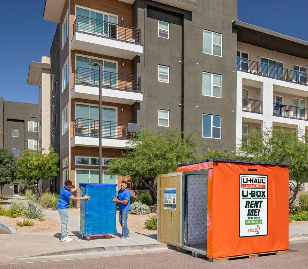Two Service Providers carefully load a piece of furniture into a U-Box storage container. You can save money when you hire labor-only Service Providers for your hybrid move.