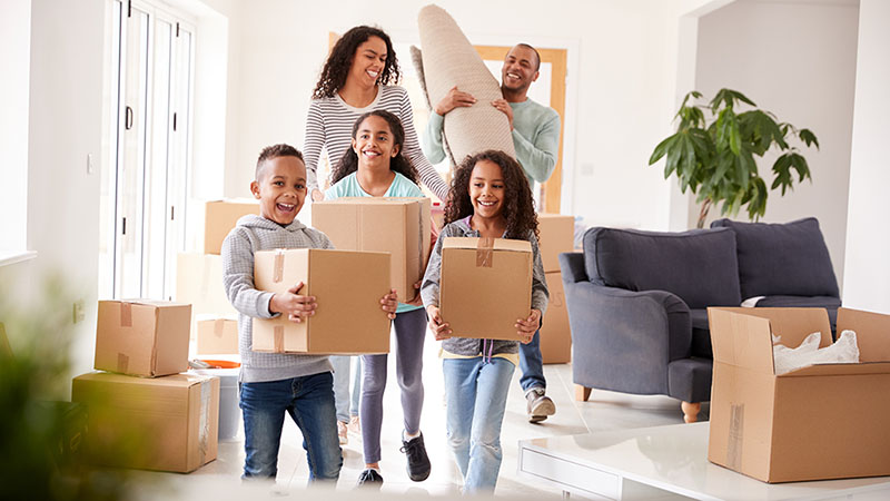 A family brings in a few items into their home from their car since their Moving Helpers unloaded everything out of their U-Haul truck rental.