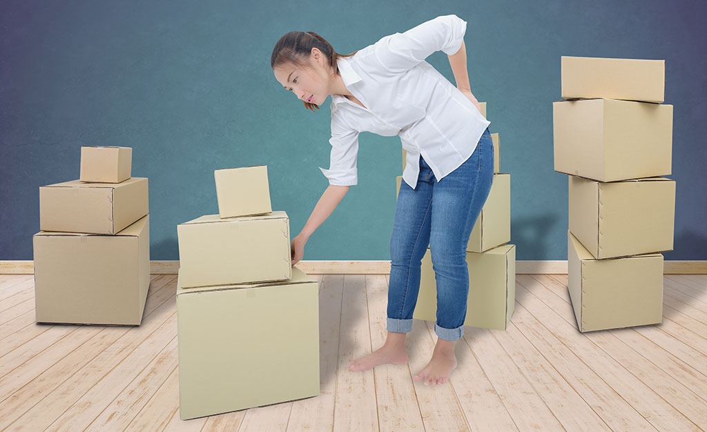 A young woman strains her back from having to lift all her heavy moving boxes by herself. When you hire moving labor Service Providers from the Moving Help Marketplace, you can avoid having to do the heavy lifting yourself, which removes the chances of physical injury or stress.