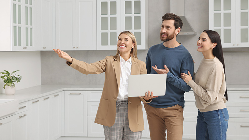 A leasing agent shows a couple the kitchen of their recently updated rental unit. You should have questions to ask when touring an apartment.