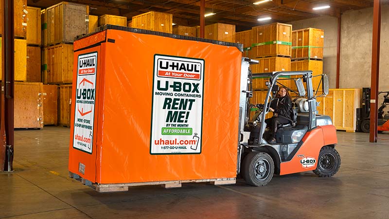 A U-Haul employee uses a forklift to move a U-Haul U-Box storage container at one of U-Haul's centers.