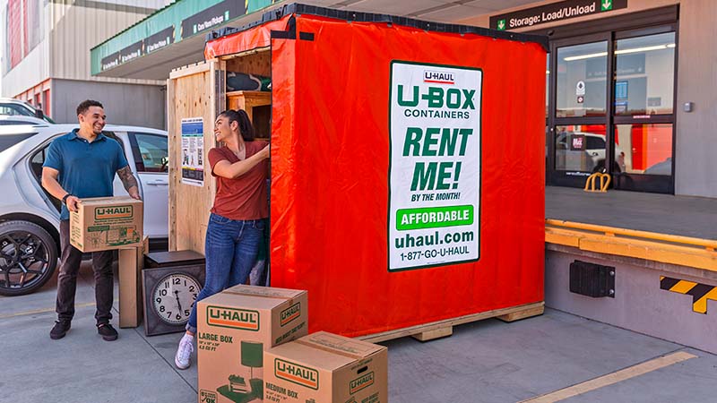 A couple begins loading U-Haul moving boxes into a U-Box storage container at a U-Haul center.