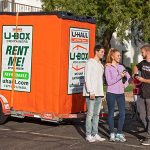 A couple talks to their Moving Help Service Provider as they prepare to give their Moving Helper his Payment Code after he delivered the U-Box storage container to the couple’s home.