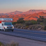 A customer drives a U-Haul truck rental on the highway in the middle of the Arizona desert.