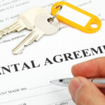 A tenant prepares to sign their rental agreement for their landlord before the tenant receives their keys.