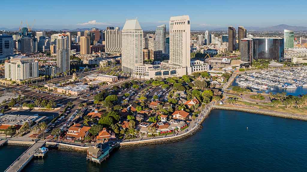 An aerial shot shows downtown San Diego along with the Seaport Village waterfront on a sunny afternoon.