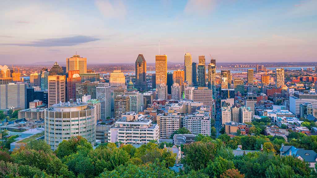 An aerial shot of the Montreal skyline can be seen on a mostly sunny day as the sun begins to set. The Moving Help Marketplace has the best labor-only movers in Montreal.