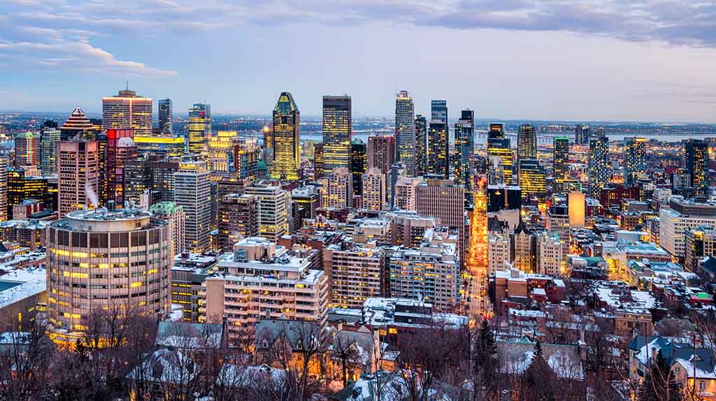 Snow covers the buildings in downtown Montreal on a cool, cloudy, wintery day. The Moving Help Marketplace has the best moving labor in Montreal.