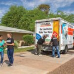 A customer provides the Payment Code to the Service Provider while the other two providers close the U-Haul truck rental behind them.