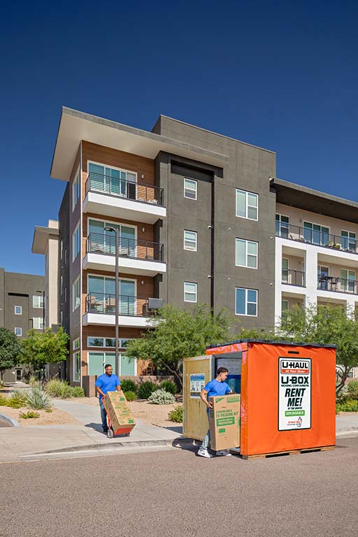 Two Service Providers bring a customer’s moving boxes into a U-Box storage container.