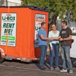 A Moving Help Service Provider shakes hands with two customers after delivering a U-Box storage container to their home. Moving cities doesn’t have to be difficult with Moving Help.