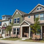 A row of townhouses stands next to one another on a sunny day. What is the difference between a townhouse and a townhome? They’re the same term but used interchangeably.