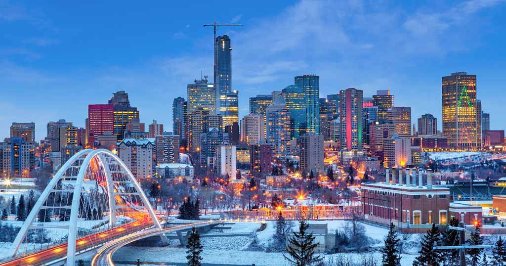 An aerial photo shows a Canadian city covered in snow on a cold, wintery evening.