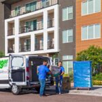 Two Moving Help Service Providers load furniture into a cargo van for a customer.