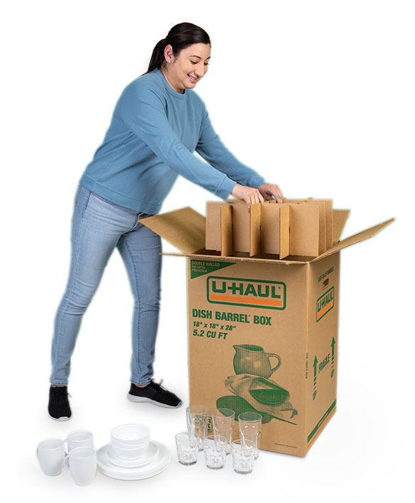 A woman begins to put her cell kit into her dish barrel box before she begins to place her cups and dishes into the dish barrel moving box.