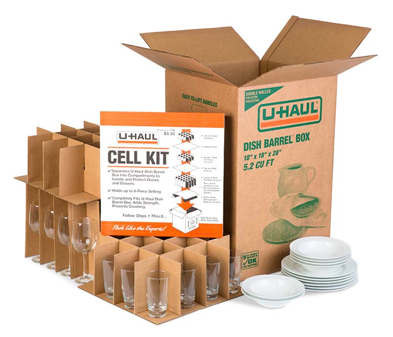 A dish barrel box, a cell kit package, two cell kits with glass cups and wine glasses, some plates, and some bowls sit next to one another.