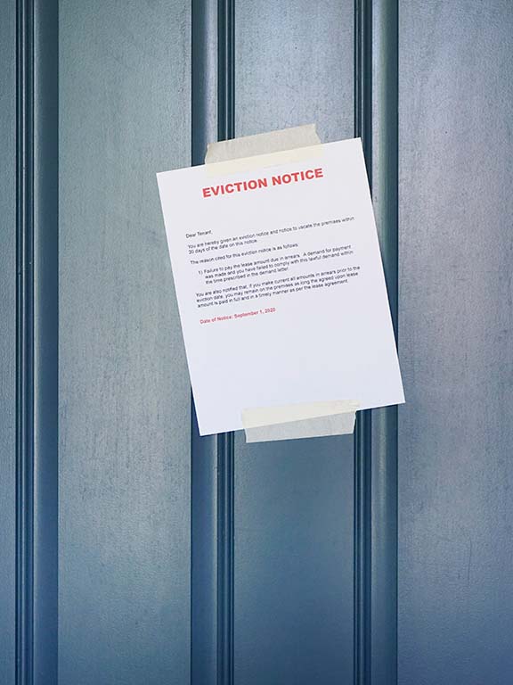 An "Eviction Notice” is taped onto a tenant’s front door.