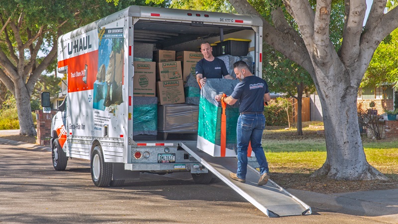 Two Moving Helpers load a U-Haul moving truck.