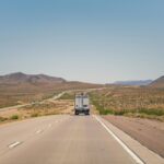 A moving truck drives on a highway in the Arizona desert.
