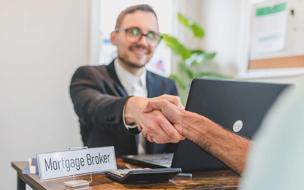 A mortgage broker shakes the hand of a customer after they were just approved for a 30-year mortgage.