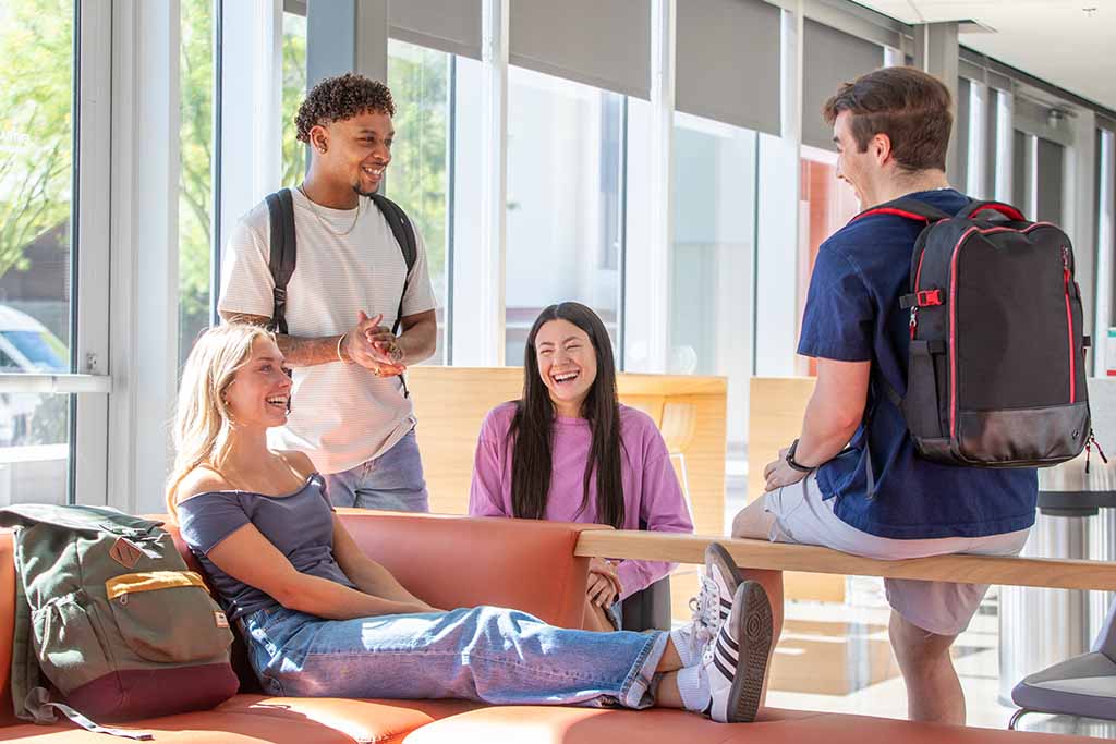 A group of college students is sitting in an academic building together.