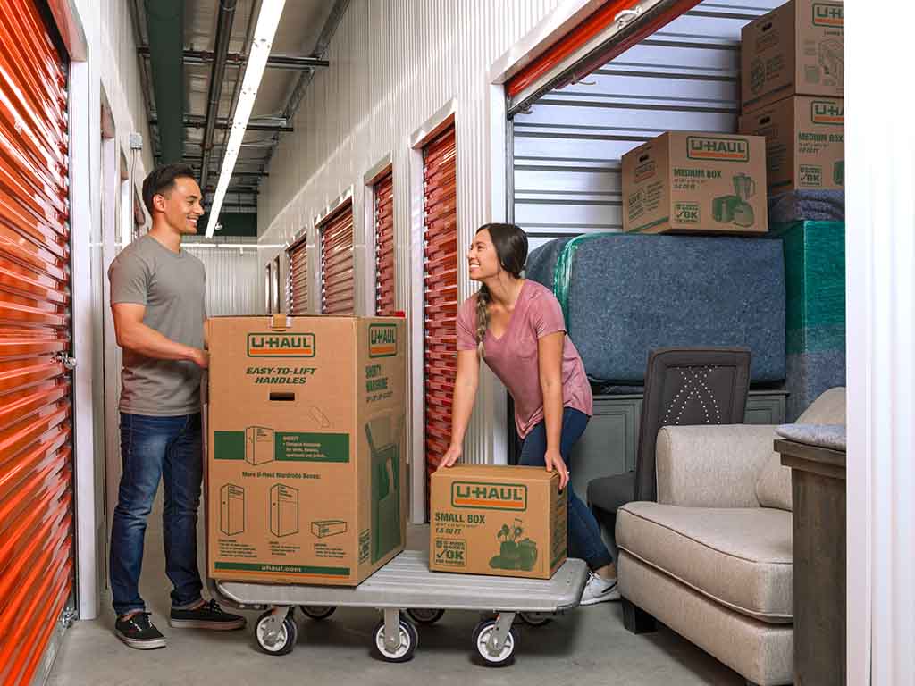 A couple unpacks a U-Haul storage unit together.